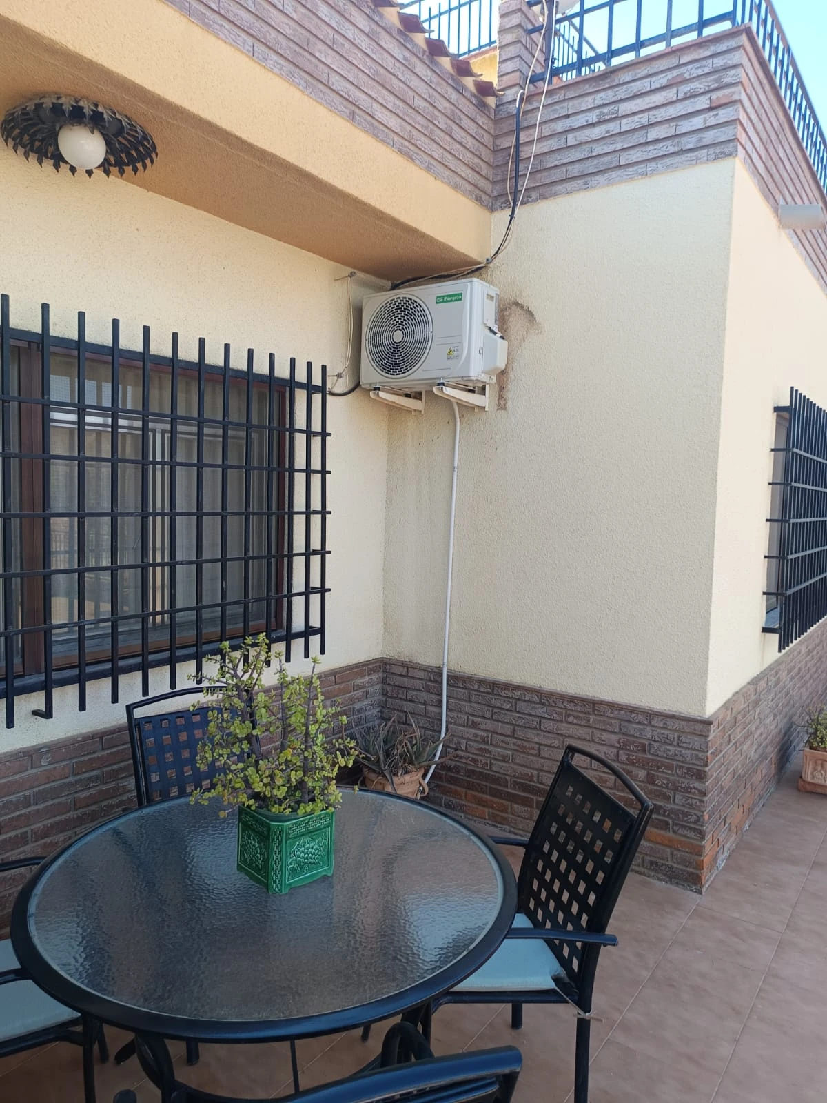 Unidad exterior de aire acondicionado recién instalada en la fachada de un ático en Zurgena.