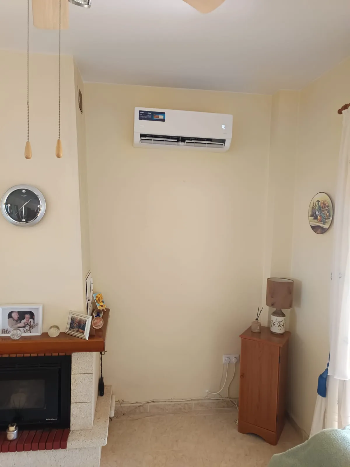 Aire acondicionado instalado en un salón con chimenea.